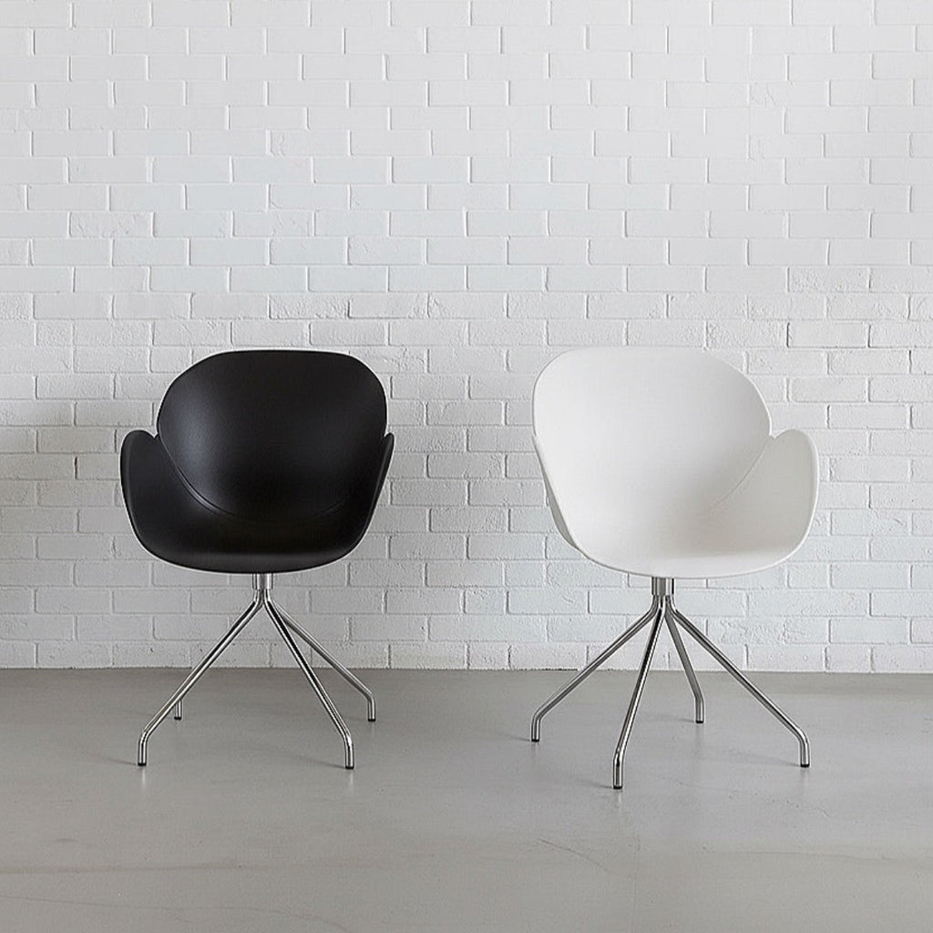 Black and white chairs with metal legs against a white brick wall.