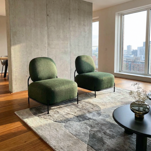 Two green armchairs in a modern living room with large windows.