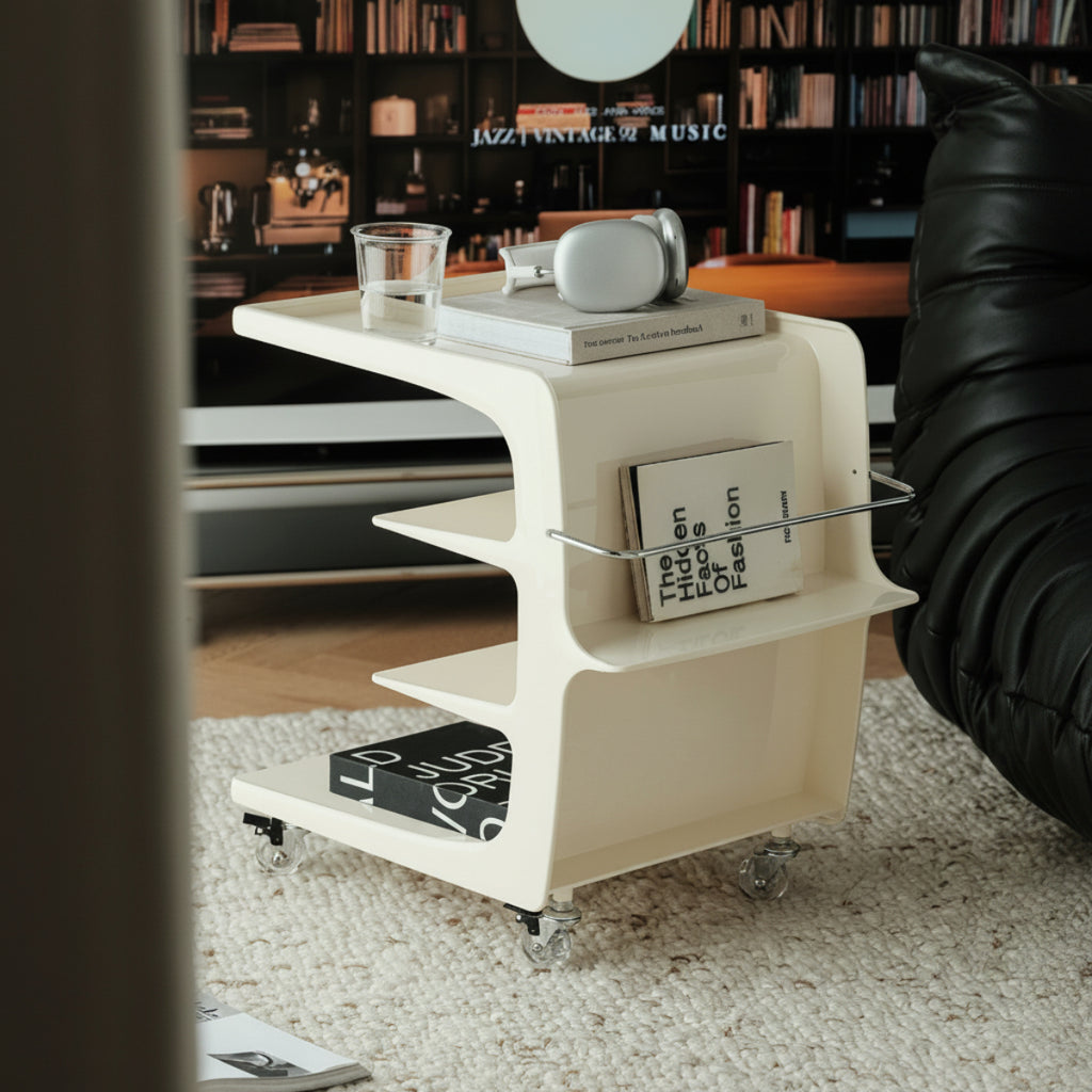 Modern white side table with books and a glass in a room with bookshelves.