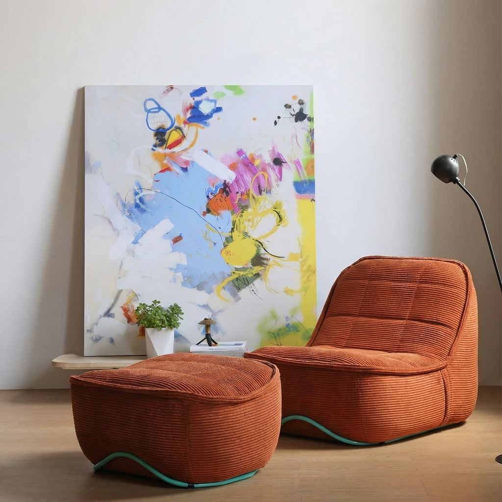 Orange lounge chair and ottoman in a room with colorful abstract art on the wall.